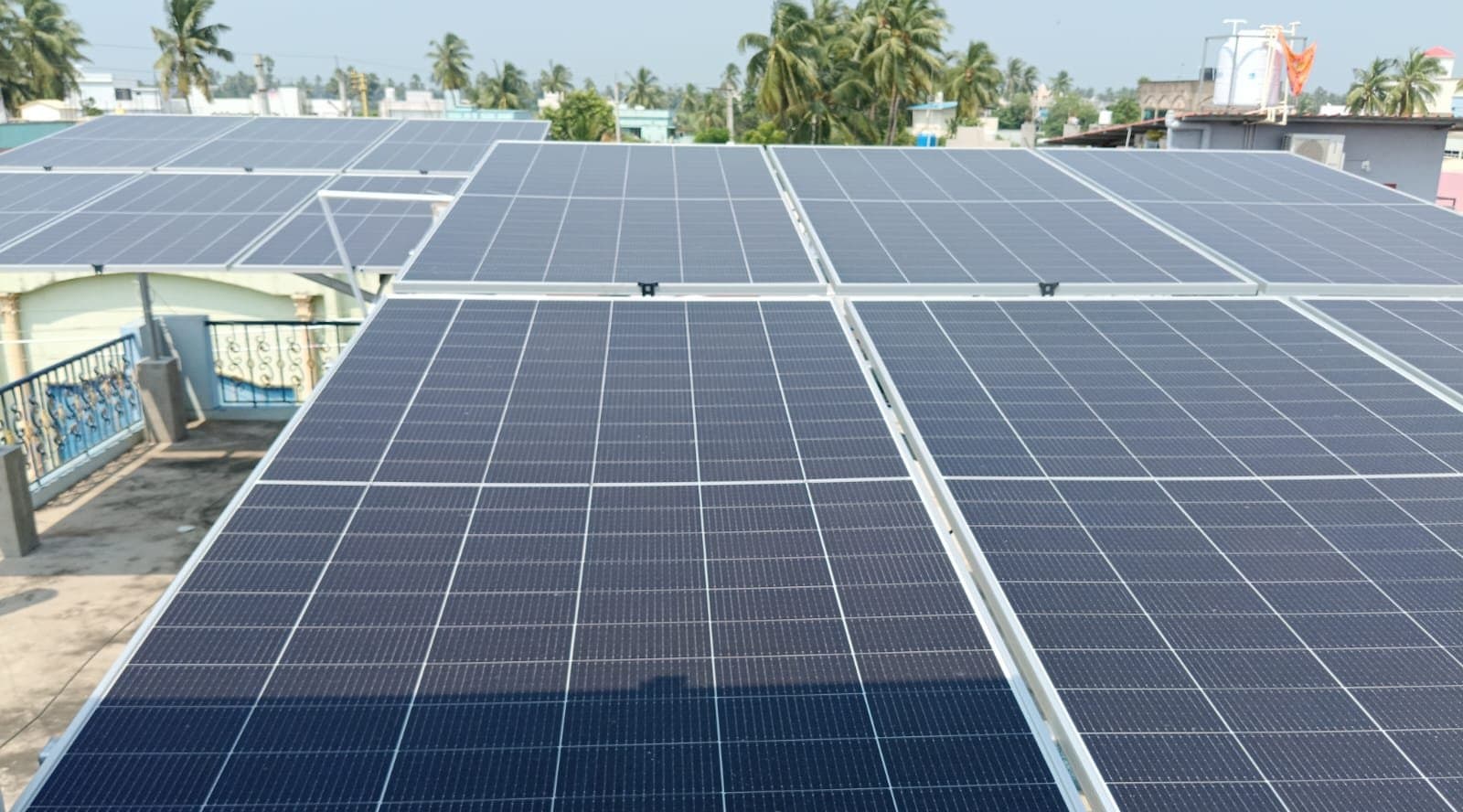 SolarTech rooftop installation with coconut palms behind, coastal Andhra Pradesh